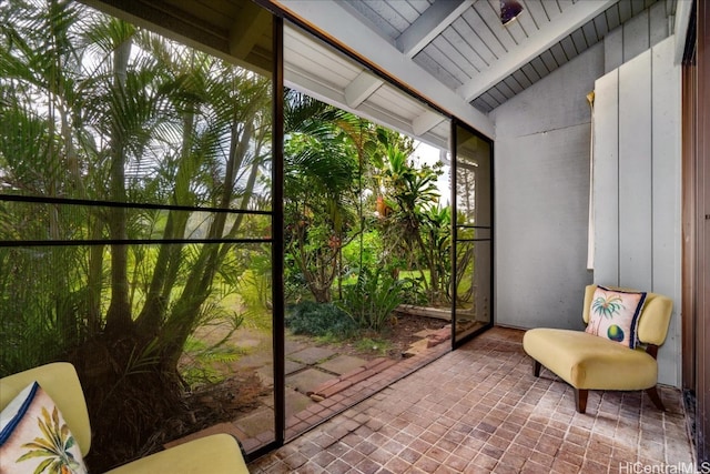 sunroom featuring lofted ceiling with beams