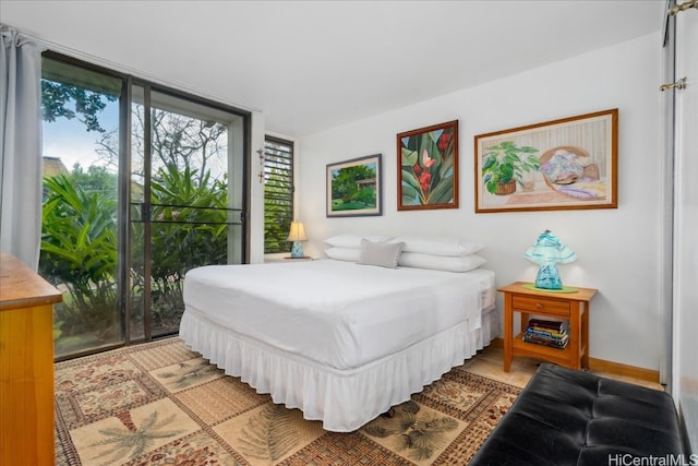 bedroom featuring expansive windows, access to outside, multiple windows, and baseboards