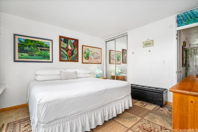 bedroom featuring baseboards, a closet, and tile patterned floors