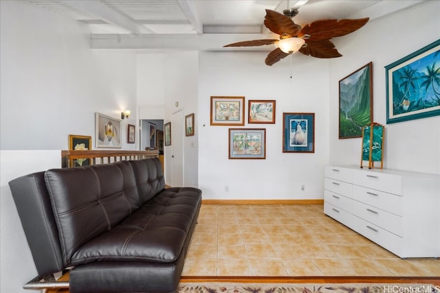 living area featuring light tile patterned floors, a ceiling fan, beam ceiling, and baseboards