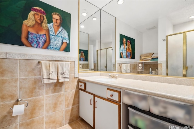 bathroom with vanity, tile patterned flooring, a shower stall, and tile walls