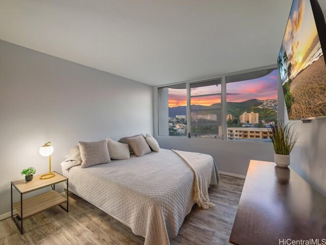 bedroom with wood finished floors and baseboards