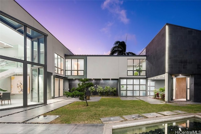 exterior space with stucco siding and a yard