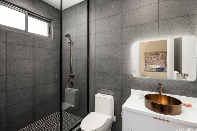 bathroom featuring vanity, a shower stall, toilet, and tile walls