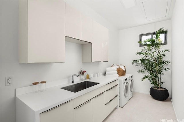 laundry room featuring baseboards, washing machine and dryer, attic access, cabinet space, and a sink