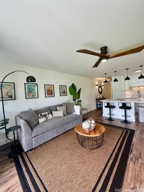 living room with baseboards, a ceiling fan, and wood finished floors