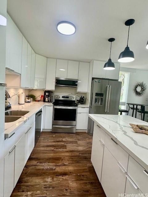 kitchen featuring dark wood-style flooring, decorative light fixtures, stainless steel appliances, white cabinetry, and a sink