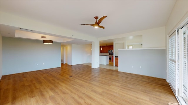 unfurnished living room featuring light wood finished floors, visible vents, and a ceiling fan