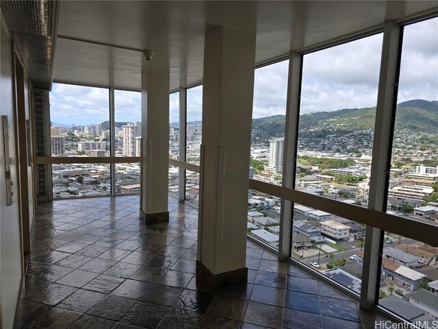 unfurnished sunroom featuring a city view and a mountain view