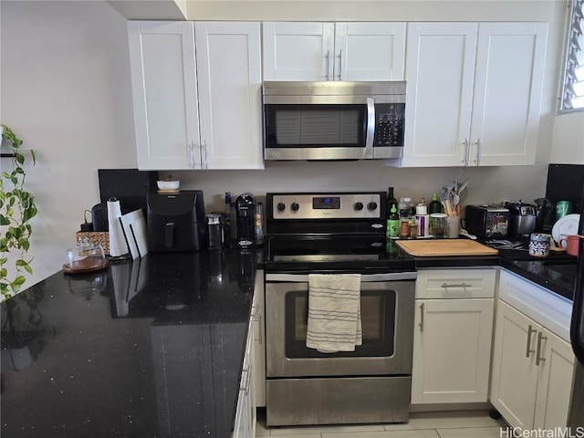 kitchen with white cabinets, dark stone counters, and stainless steel appliances