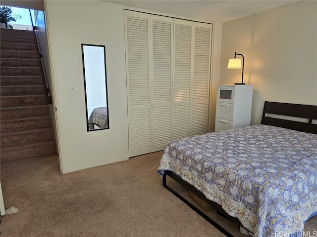 carpeted bedroom featuring a closet and a textured ceiling