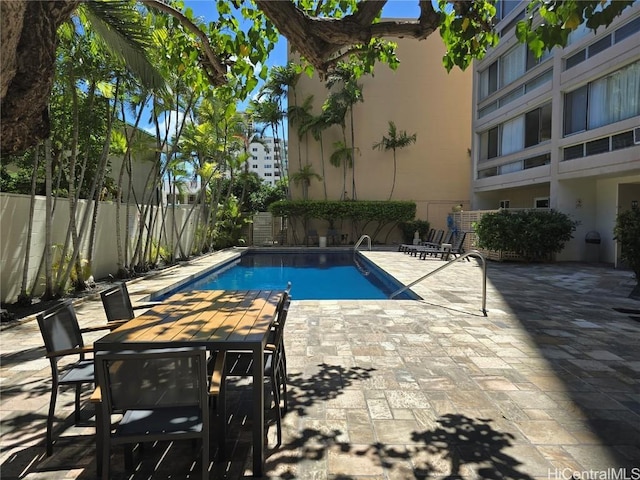 pool with a fenced backyard and a patio