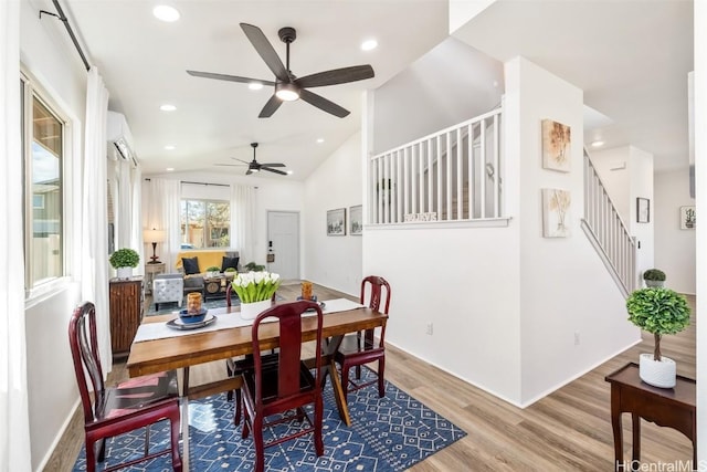 dining area with lofted ceiling, stairs, wood finished floors, and recessed lighting