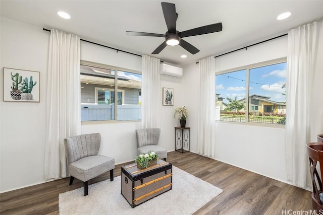 sitting room with recessed lighting, a wall mounted air conditioner, ceiling fan, and wood finished floors