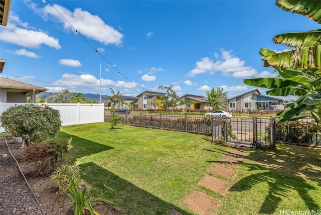 view of yard featuring a fenced backyard and a residential view