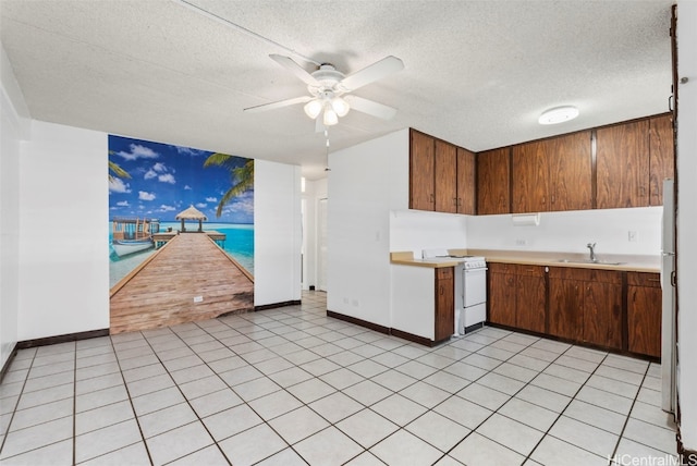 kitchen with light countertops, a ceiling fan, a sink, a textured ceiling, and white appliances