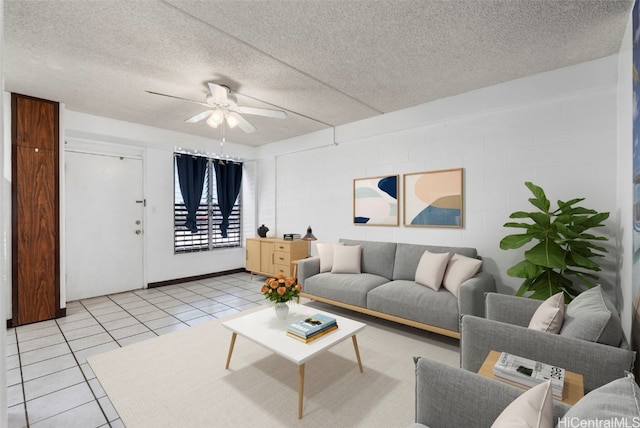 living room with a ceiling fan, a textured ceiling, and light tile patterned flooring