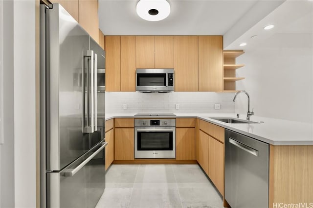 kitchen with tasteful backsplash, stainless steel appliances, light countertops, open shelves, and a sink