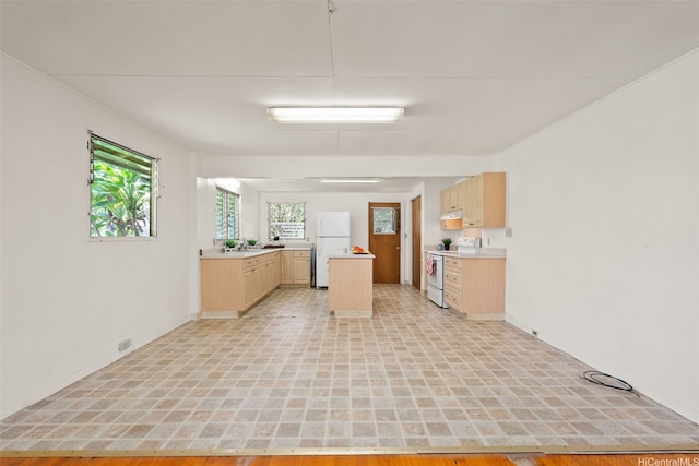 66-826 Haleiwa Rd, Haleiwa, HI 96712 - kitchen with white appliances, light countertops, baseboards, and light brown cabinets