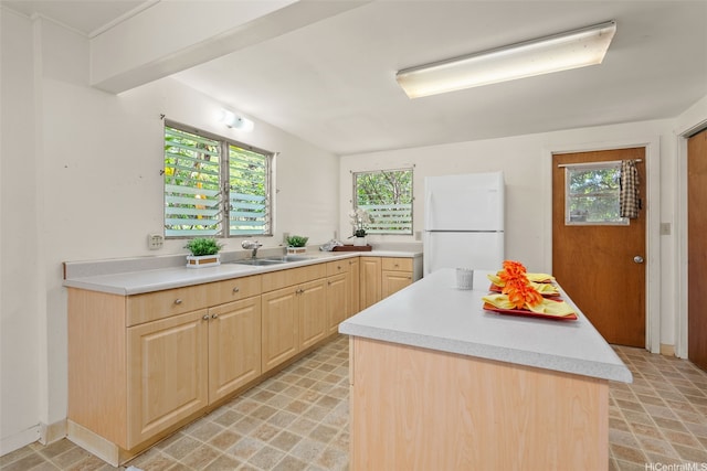 66-826 Haleiwa Rd, Haleiwa, HI 96712 - kitchen with light brown cabinetry, a sink, light countertops, freestanding refrigerator, and a healthy amount of sunlight