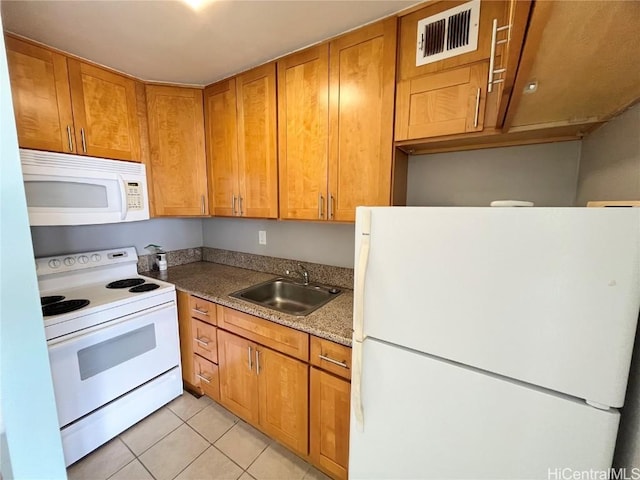 kitchen featuring white appliances, light tile patterned floors, visible vents, brown cabinets, and a sink