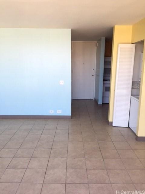 unfurnished room featuring light tile patterned floors and baseboards