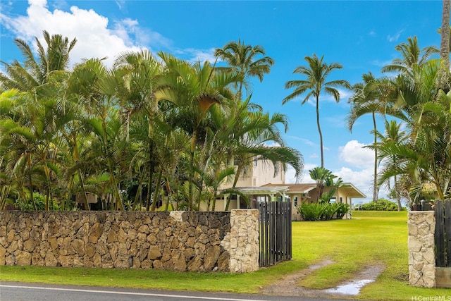 community sign with a yard, a gate, and fence