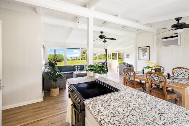 kitchen with electric stove, lofted ceiling with beams, light wood-style floors, ceiling fan, and open floor plan