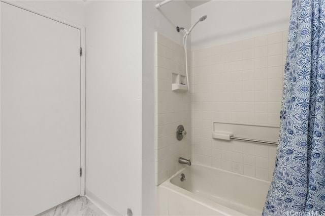 bathroom with marble finish floor and shower / bath combo with shower curtain