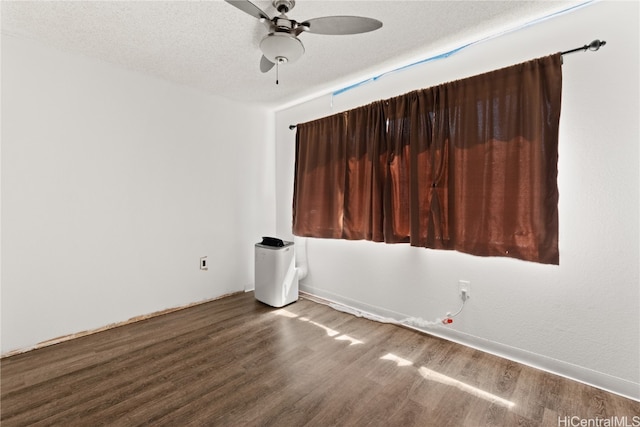 spare room with a textured ceiling, ceiling fan, and wood finished floors