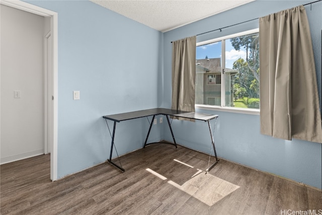 unfurnished office with a textured ceiling and wood finished floors