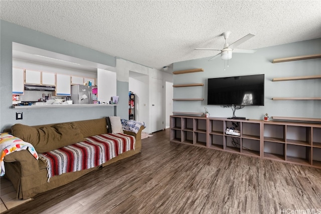 living room with a ceiling fan, a textured ceiling, and wood finished floors