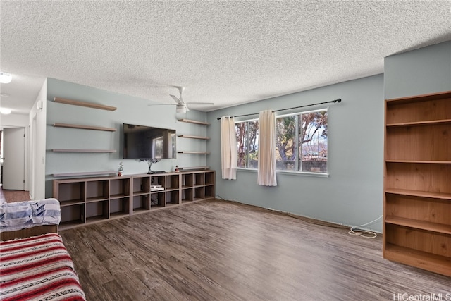 living area with ceiling fan, a textured ceiling, and wood finished floors