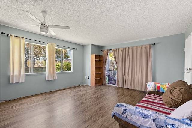 living room featuring a textured ceiling, wood finished floors, and a ceiling fan