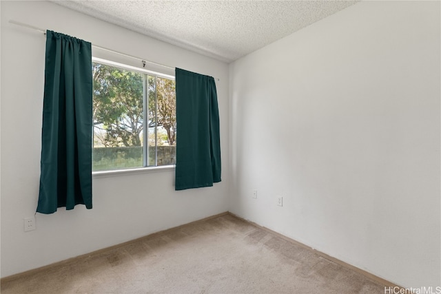 carpeted empty room featuring a textured ceiling