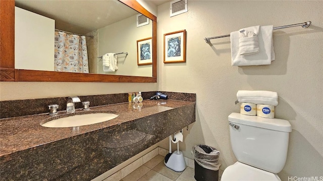 full bathroom featuring toilet, visible vents, a sink, and tile patterned floors