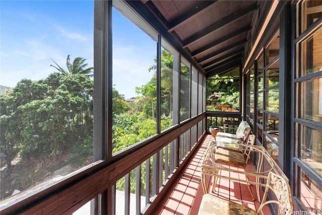 unfurnished sunroom with plenty of natural light, wood ceiling, and vaulted ceiling with beams