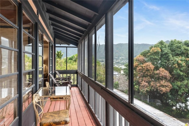 sunroom / solarium featuring lofted ceiling with beams and a mountain view