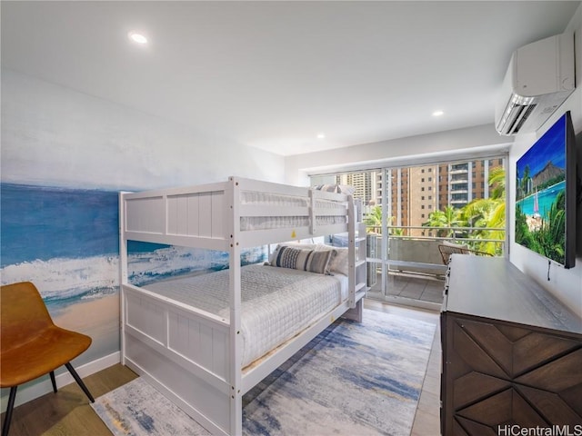 bedroom with recessed lighting, wood finished floors, and a wall mounted AC