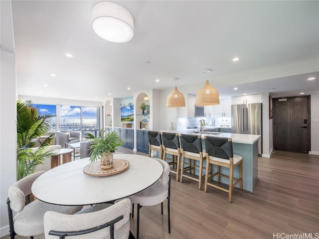 dining space with light wood-type flooring and recessed lighting