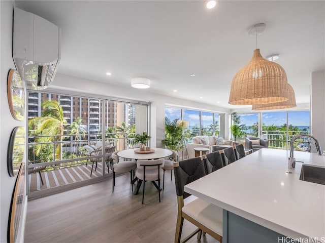 kitchen with pendant lighting, recessed lighting, light countertops, light wood-style floors, and a sink