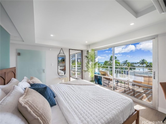 bedroom with access to outside, wood finished floors, and recessed lighting