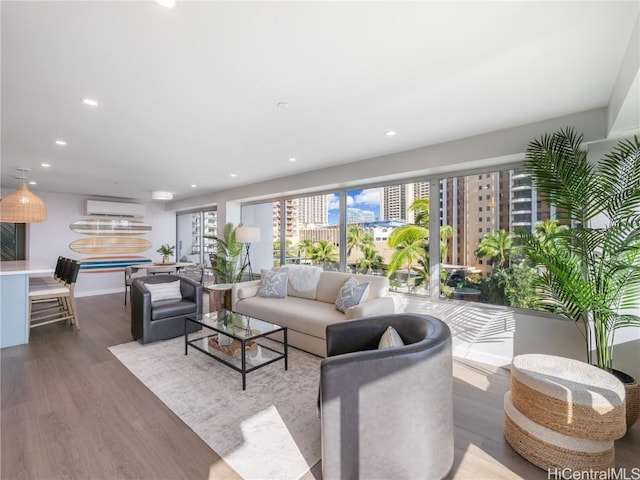 living room with recessed lighting, baseboards, wood finished floors, and a wall mounted air conditioner