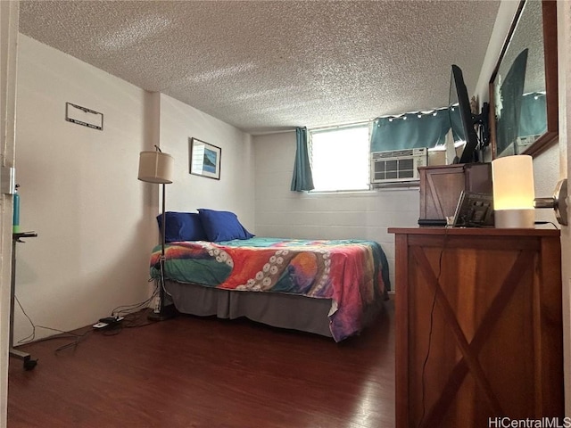 bedroom with cooling unit, a textured ceiling, wood finished floors, and concrete block wall