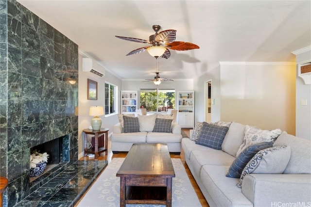 living area featuring ornamental molding, a ceiling fan, a wall unit AC, and a premium fireplace