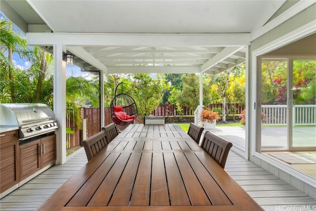 wooden deck featuring outdoor dining space, a grill, and fence