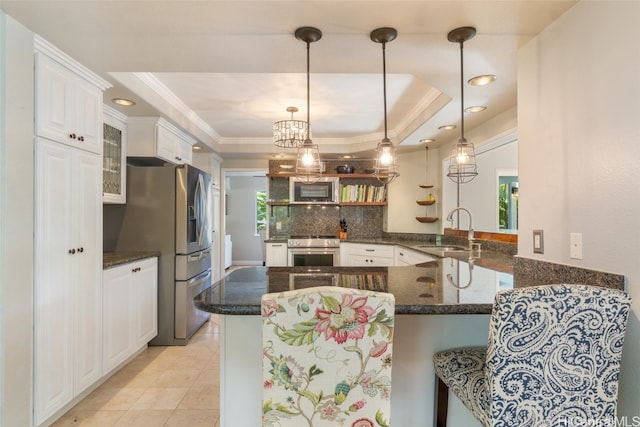 kitchen featuring white cabinets, a tray ceiling, stainless steel appliances, and a sink