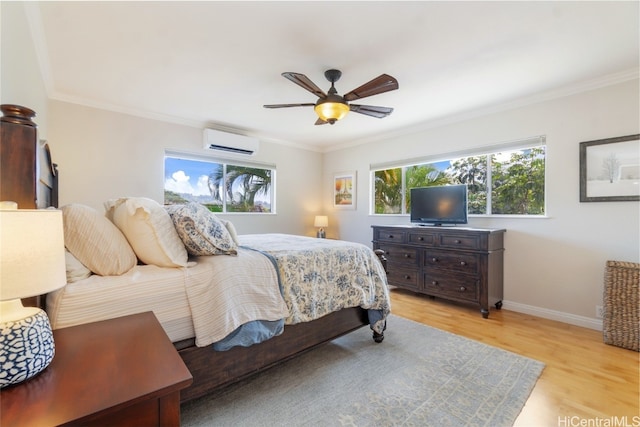 bedroom with a wall unit AC, a ceiling fan, baseboards, light wood-type flooring, and crown molding