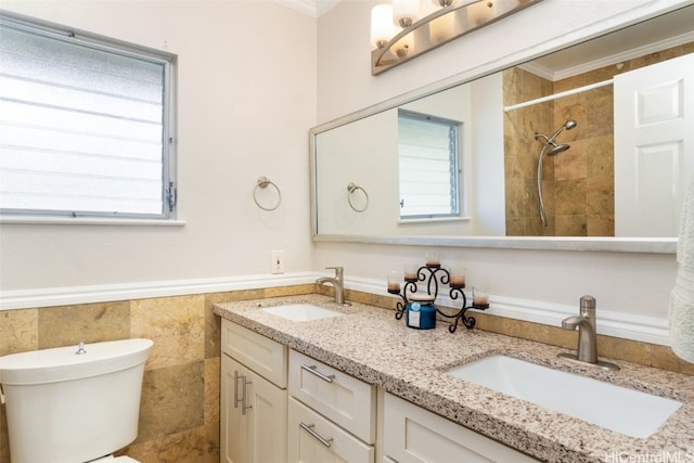 bathroom featuring a wainscoted wall, ornamental molding, a sink, and toilet