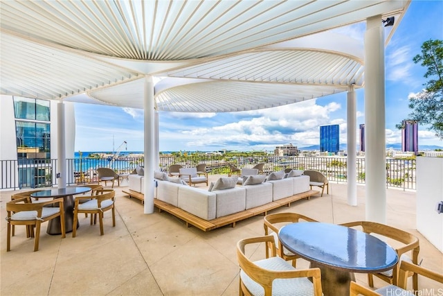 view of patio featuring a water view, a city view, outdoor dining space, and outdoor lounge area